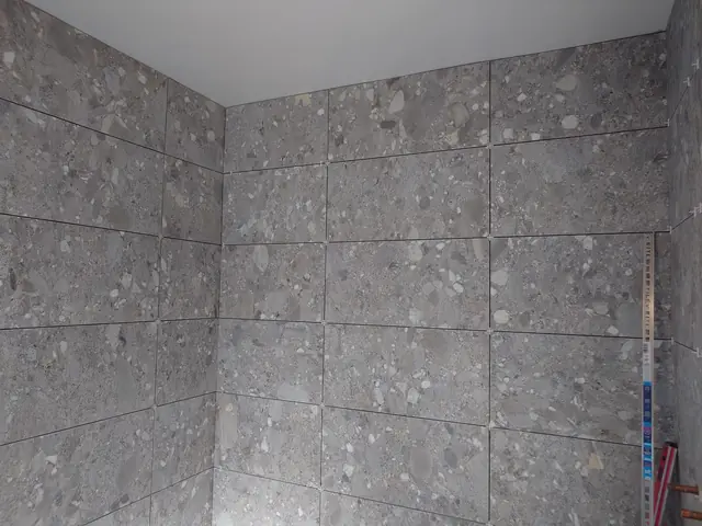 Finished floor-to-ceiling stone-effect porcelain in a shower enclosure